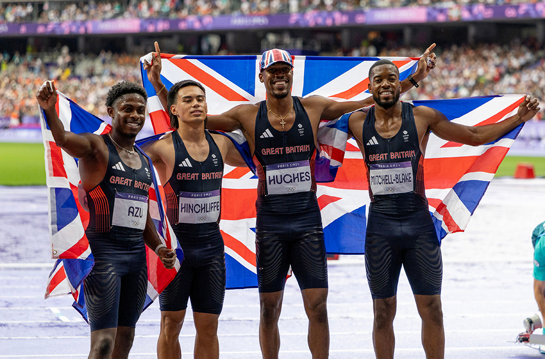 Jeremiah Azu celebrating with the GB flag with his relay teammates